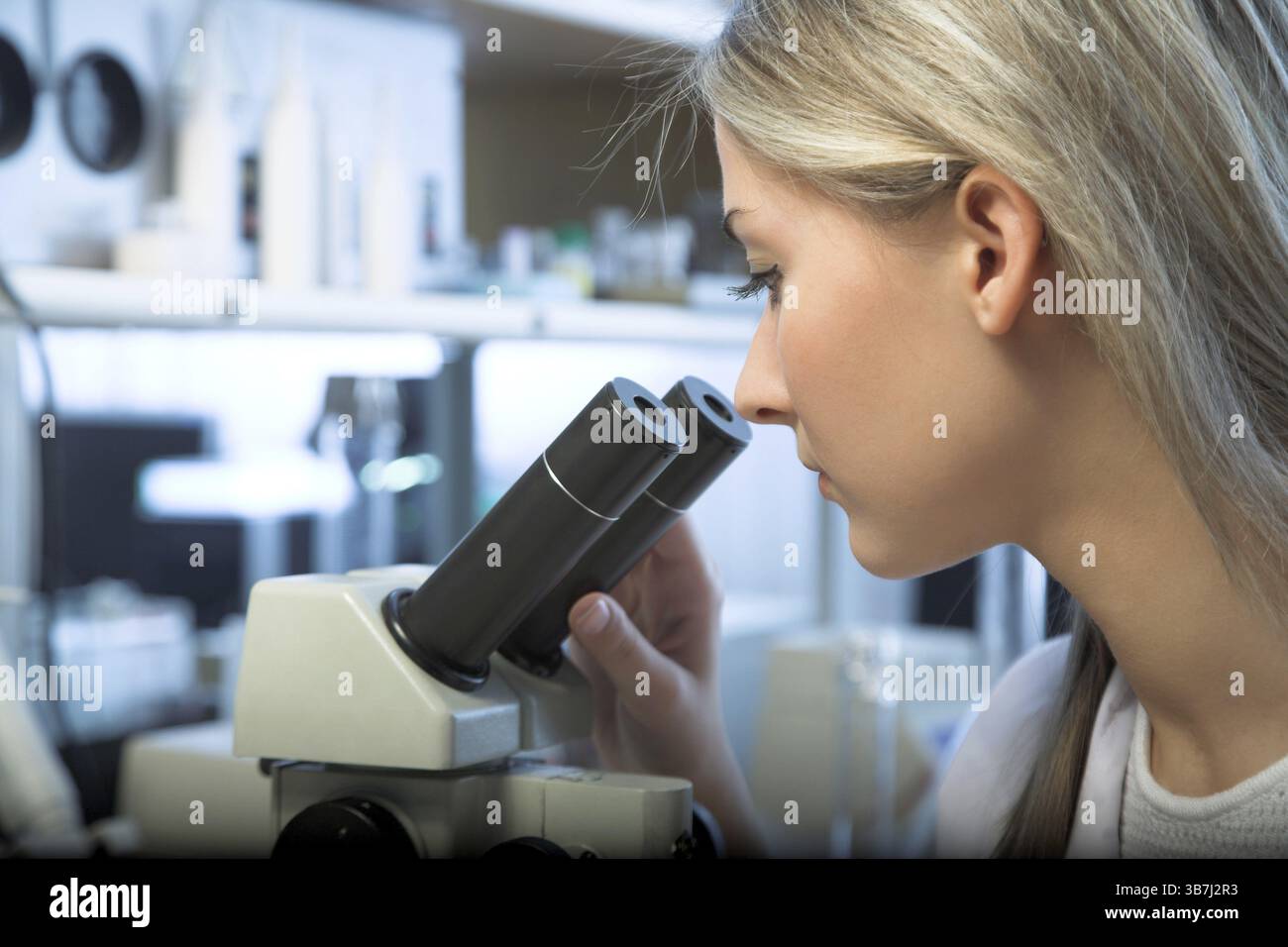 Beauty researcher looking through microscope in laboratory Stock Photo