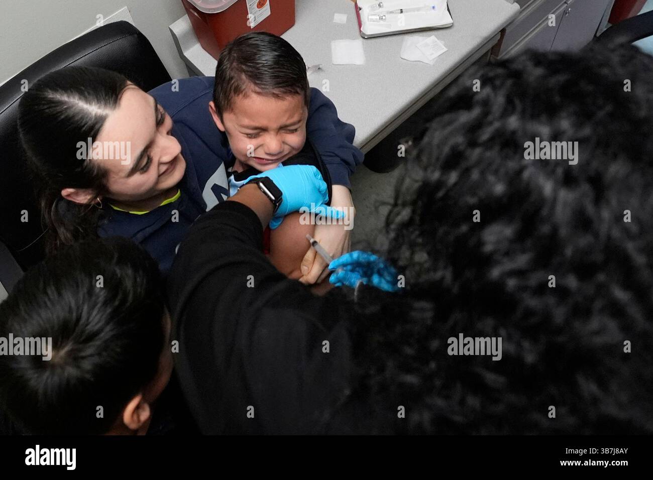 Five-year-old Ian Rojas, center his held by his mother Nicole Rodriguez ...