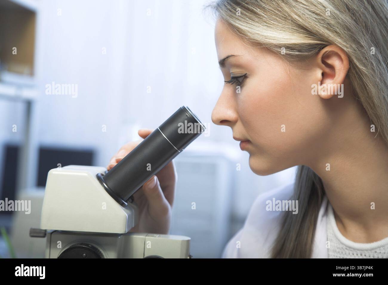 Beauty researcher looking through microscope in laboratory Stock Photo