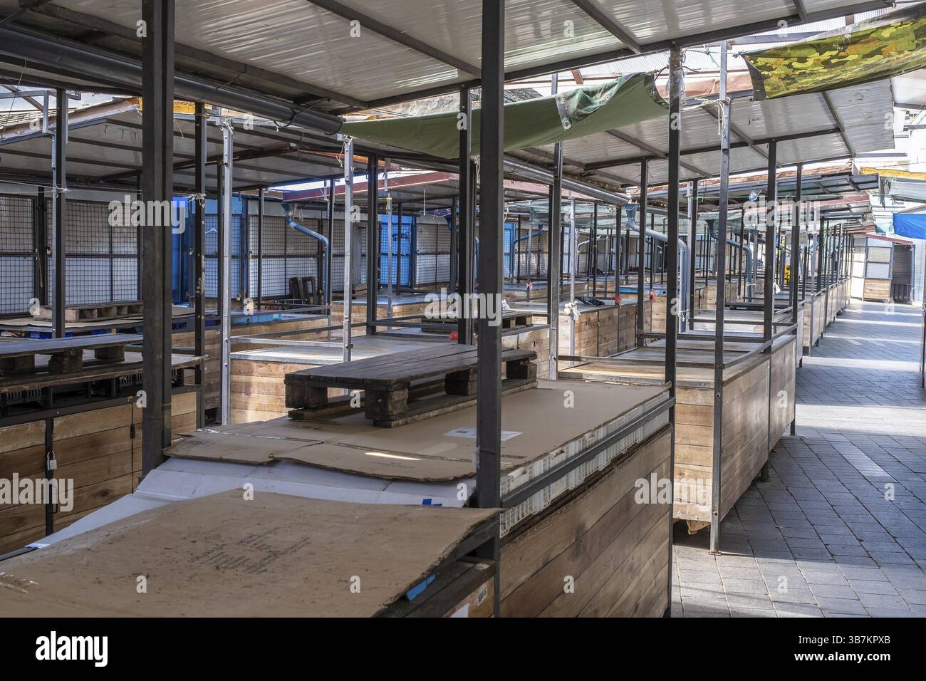 Empty covered market with wooden stalls and metal racks Stock Photo - Alamy
