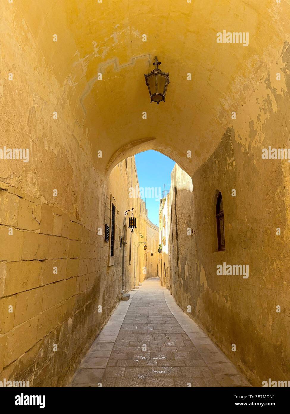 Mdina, Malta - 4 August 2023: One of the narrow streets of the old city of Mdina viewed through an archway - Smartphone Captured Stock Image