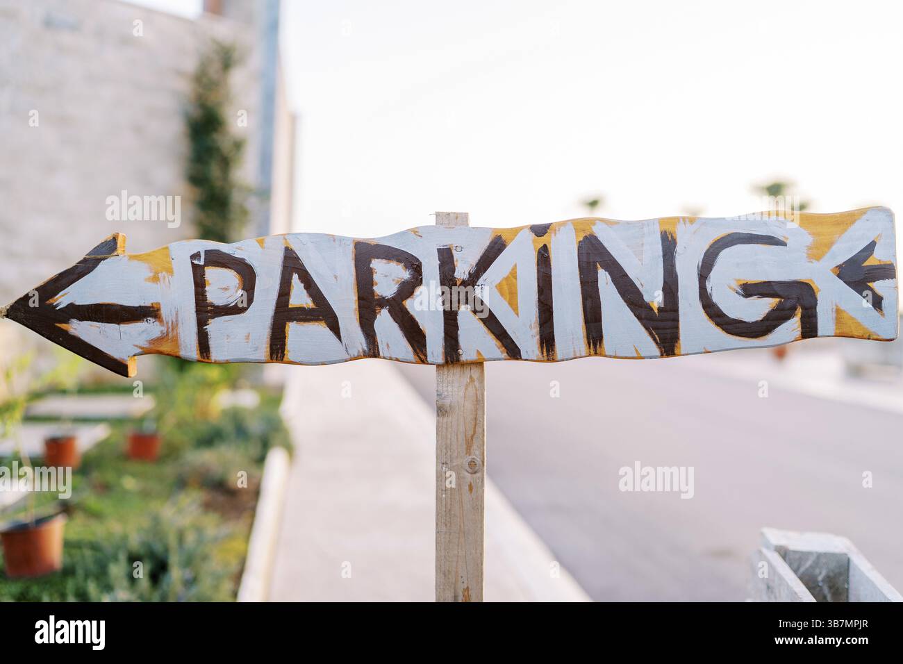 Wooden pointer with an arrow. Caption: Parking. Stock Photo