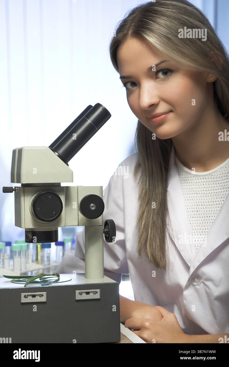 Beauty researcher looking through microscope in laboratory Stock Photo