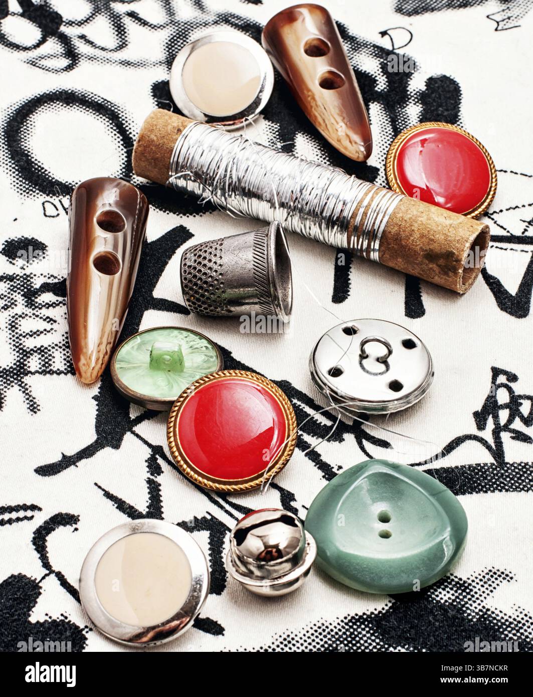 Silver bobbin of thread and a set of buttons Stock Photo - Alamy