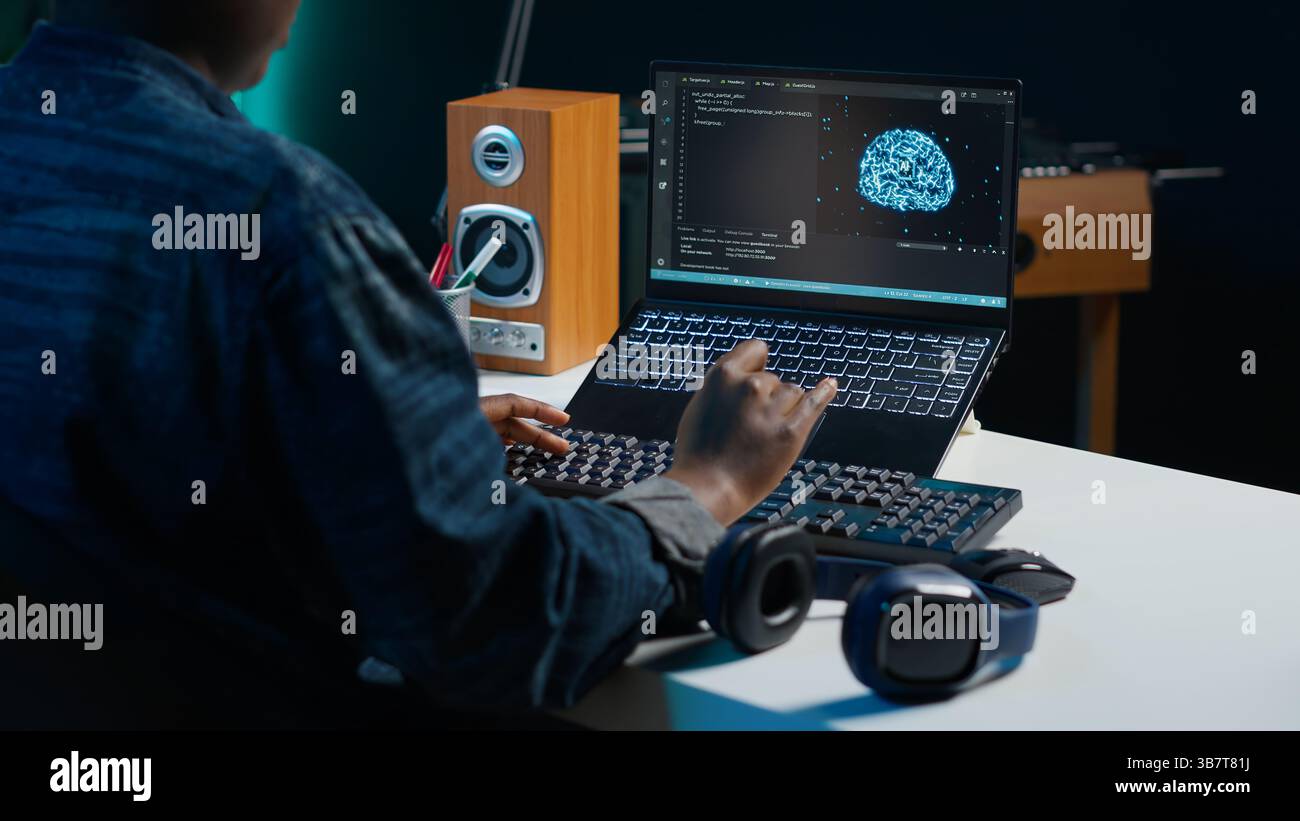 Computer scientist updating artificial intelligence neural networks, writing binary code scripts. Remote worker in apartment office uses digital device programming to upgrade AI, camera A Stock Photo