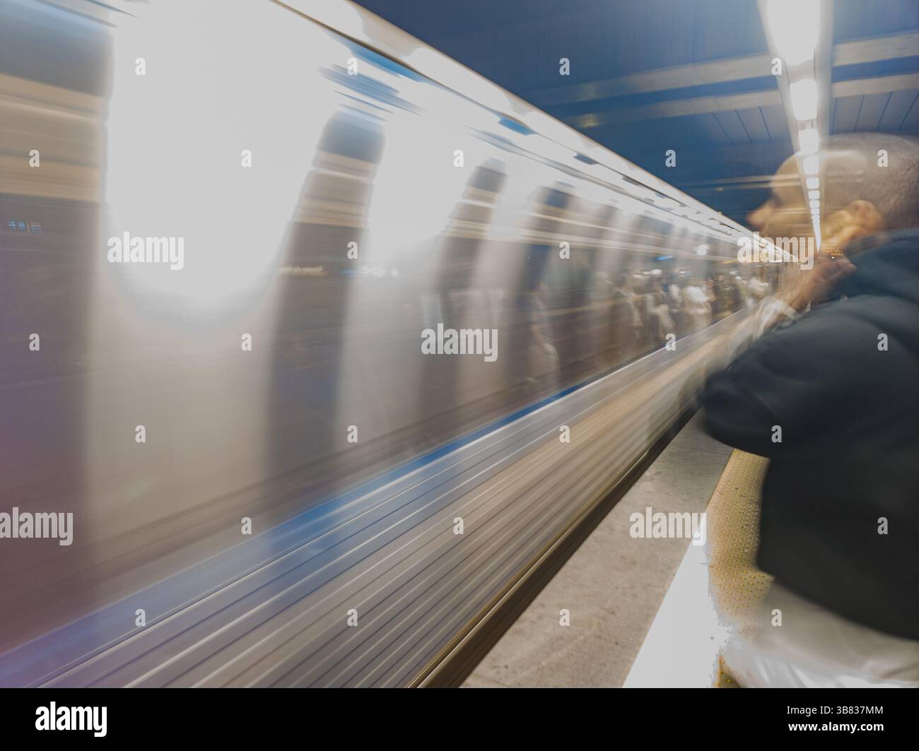 image suggestive of mental state suffering due to stress, noise of transport, interior of metro station with train passing in blurred motion. Stock Photo