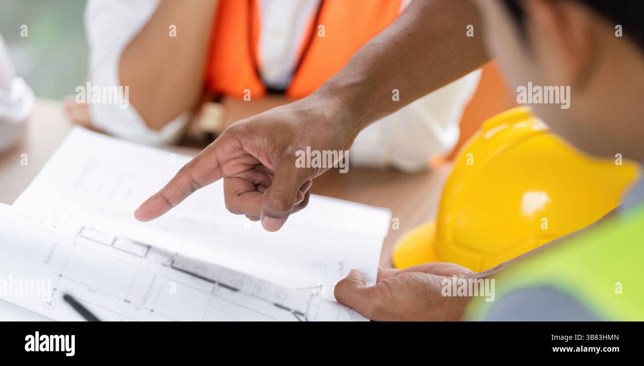 Green tech engineers analyzing plans for sustainable construction Stock Photo