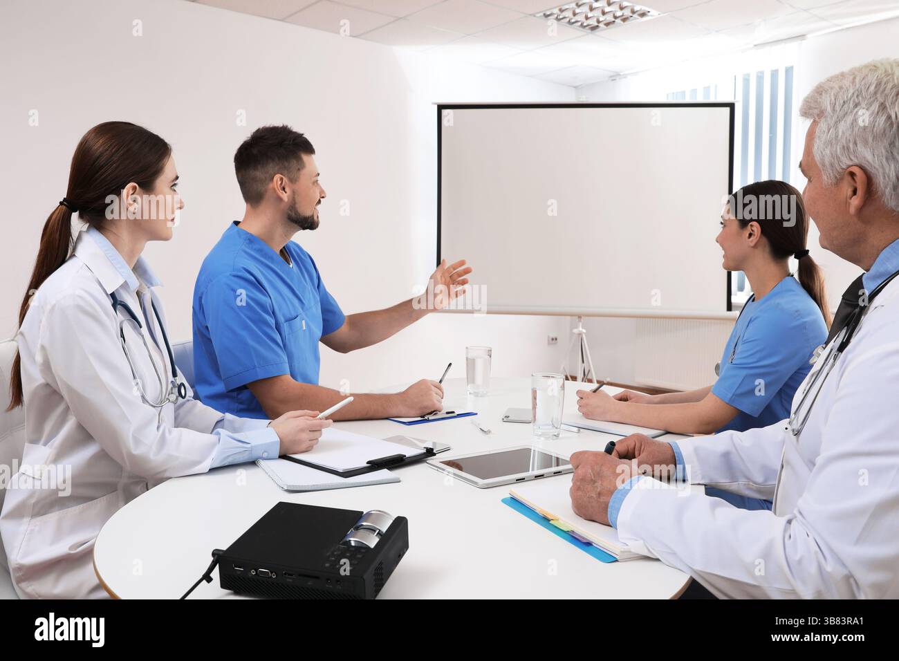 Team of doctors using video projector during conference indoors Stock Photo