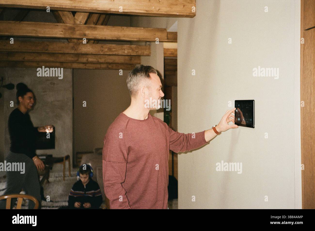 Smiling man using tablet PC mounted on wall at home Stock Photo