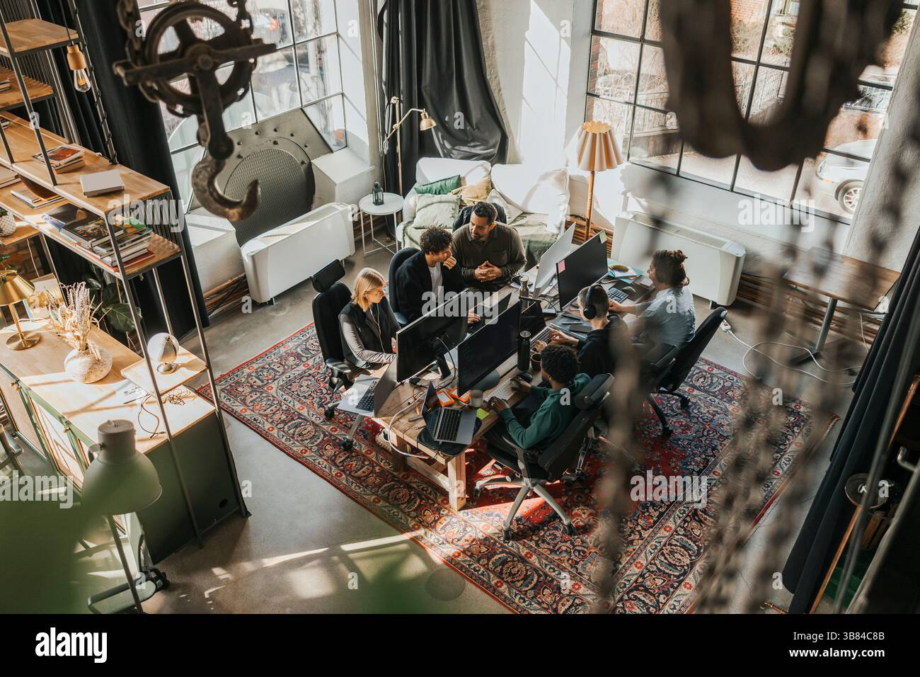 High angle view of multiracial software engineers coding while working sitting at desk in startup office Stock Photo