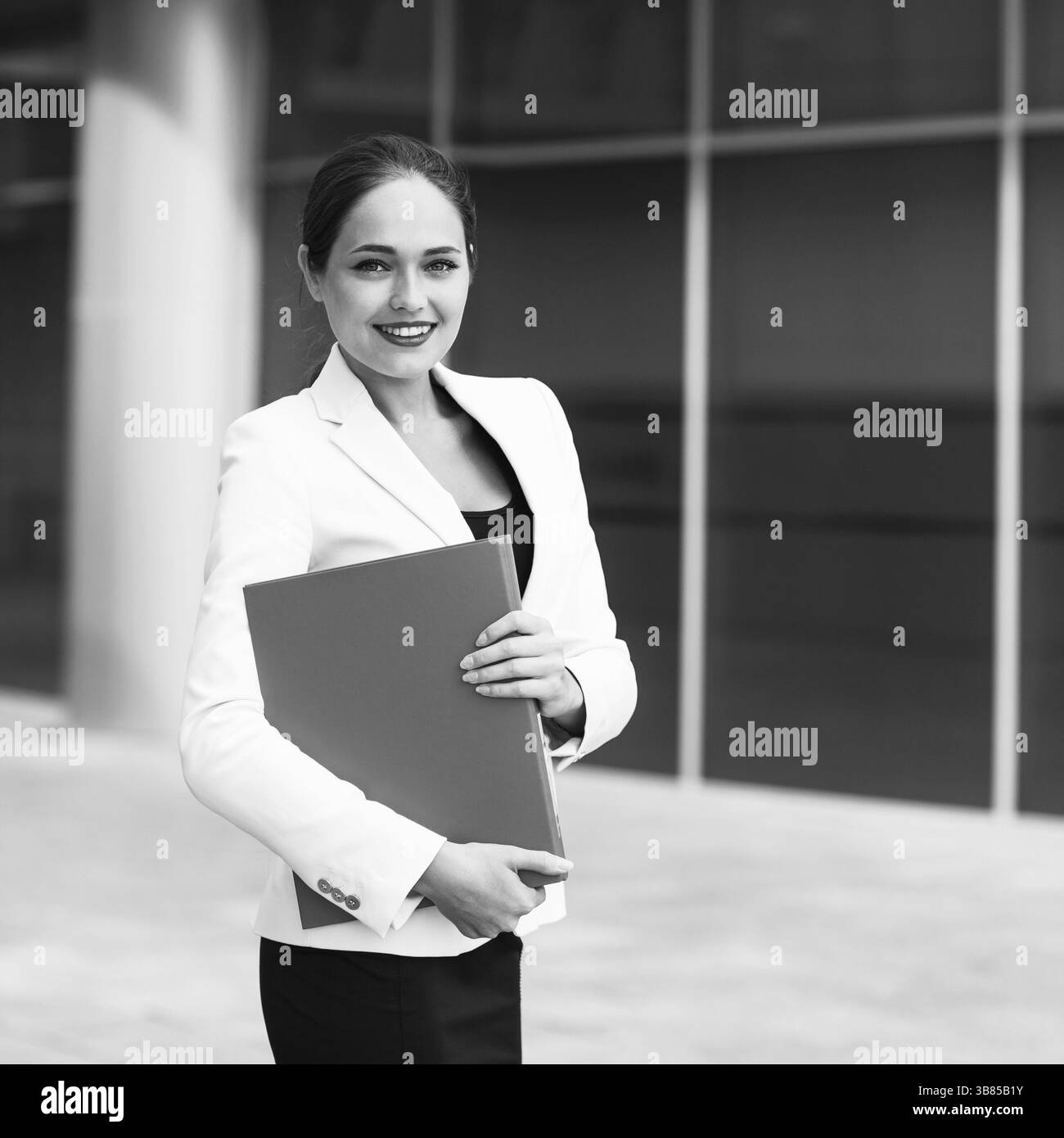 Happy young business woman with a folder at the office building Stock ...