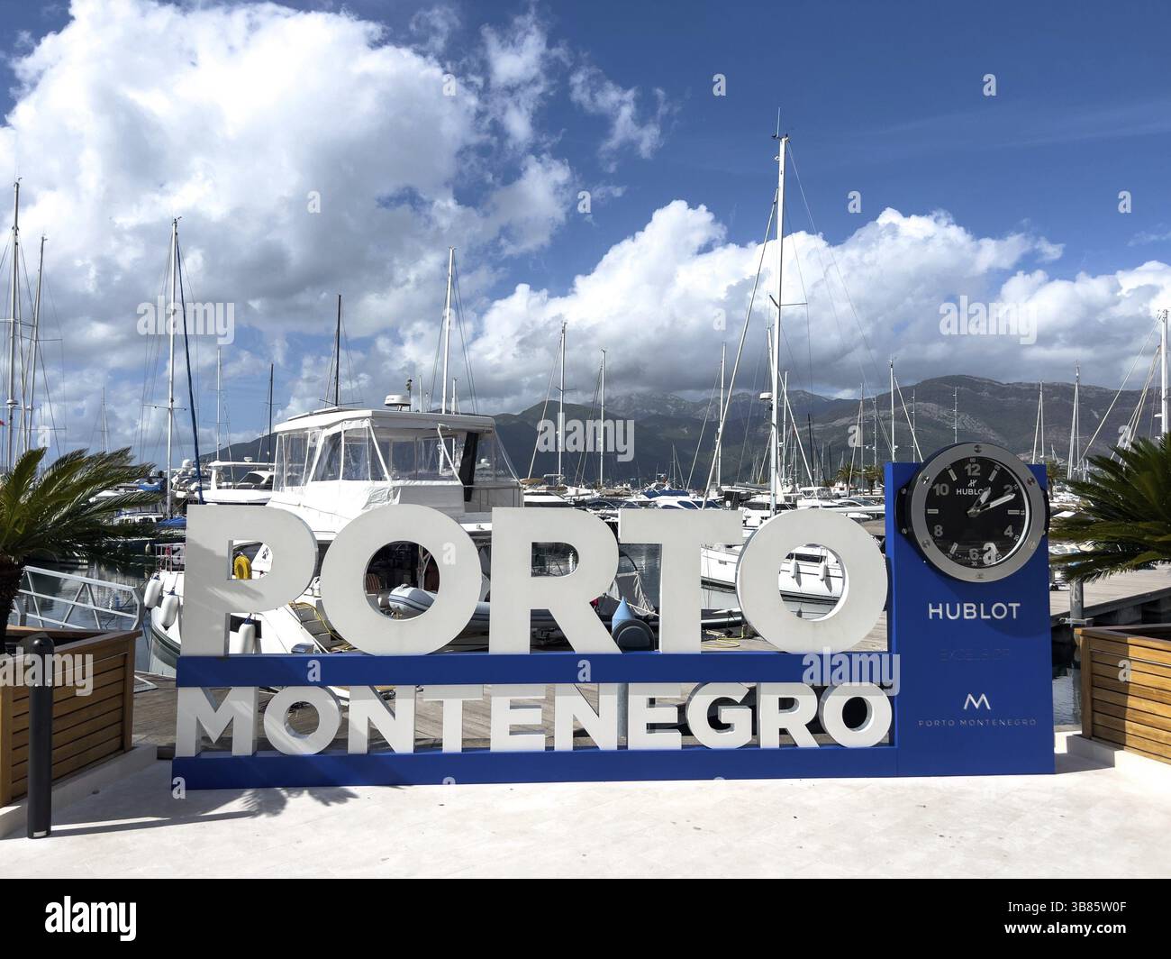 Tivat, Montenegro - 11 august 2023: Sign on the stele with a clock on the background of the yachts. Caption: Porto, Montenegro, Europe Stock Photo