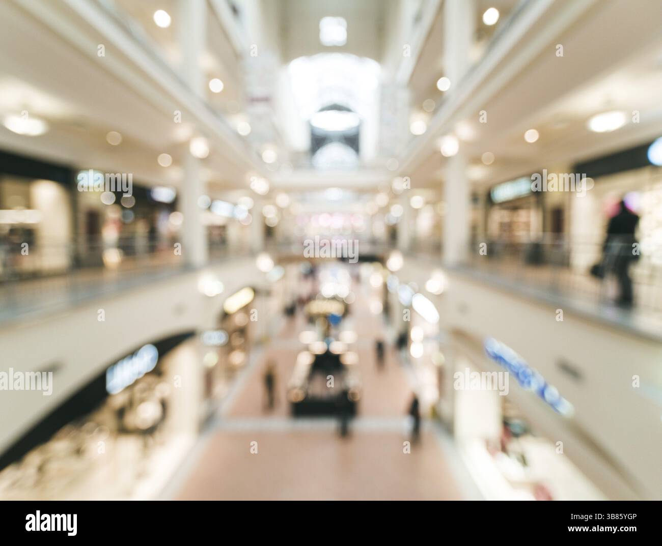 Shopping mall blur background with bokeh. Blurred hall of shopping mall with customers as background. Copy space Stock Photo