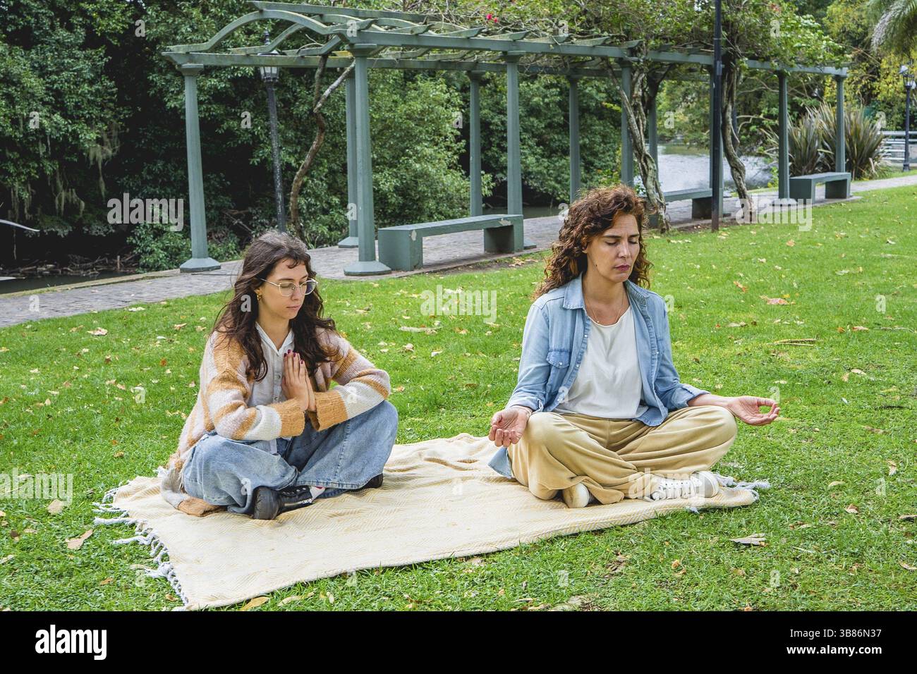 Two women practicing mindfulness and meditation on grass Stock Photo
