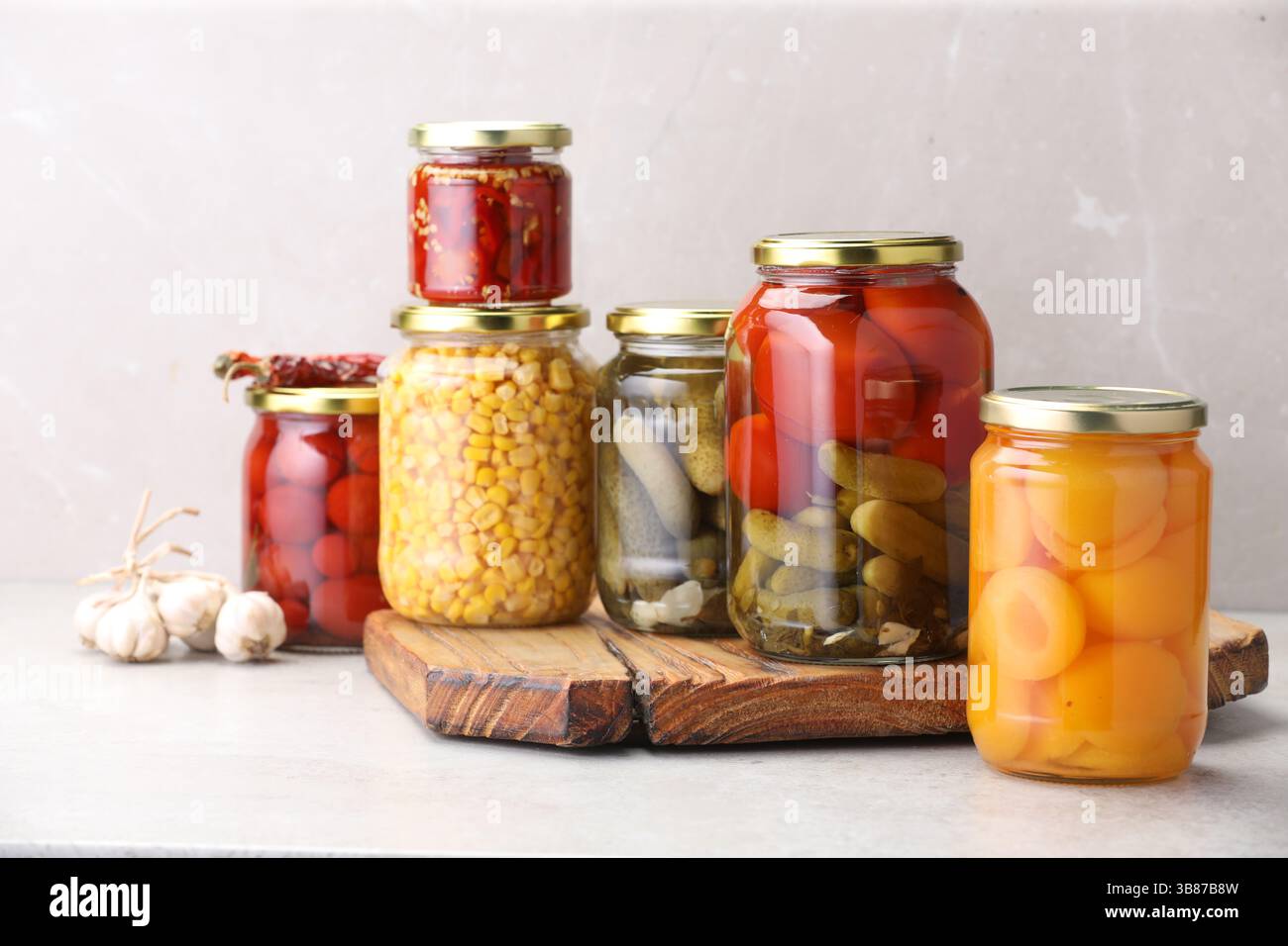 Many jars with different pickled products on light table Stock Photo