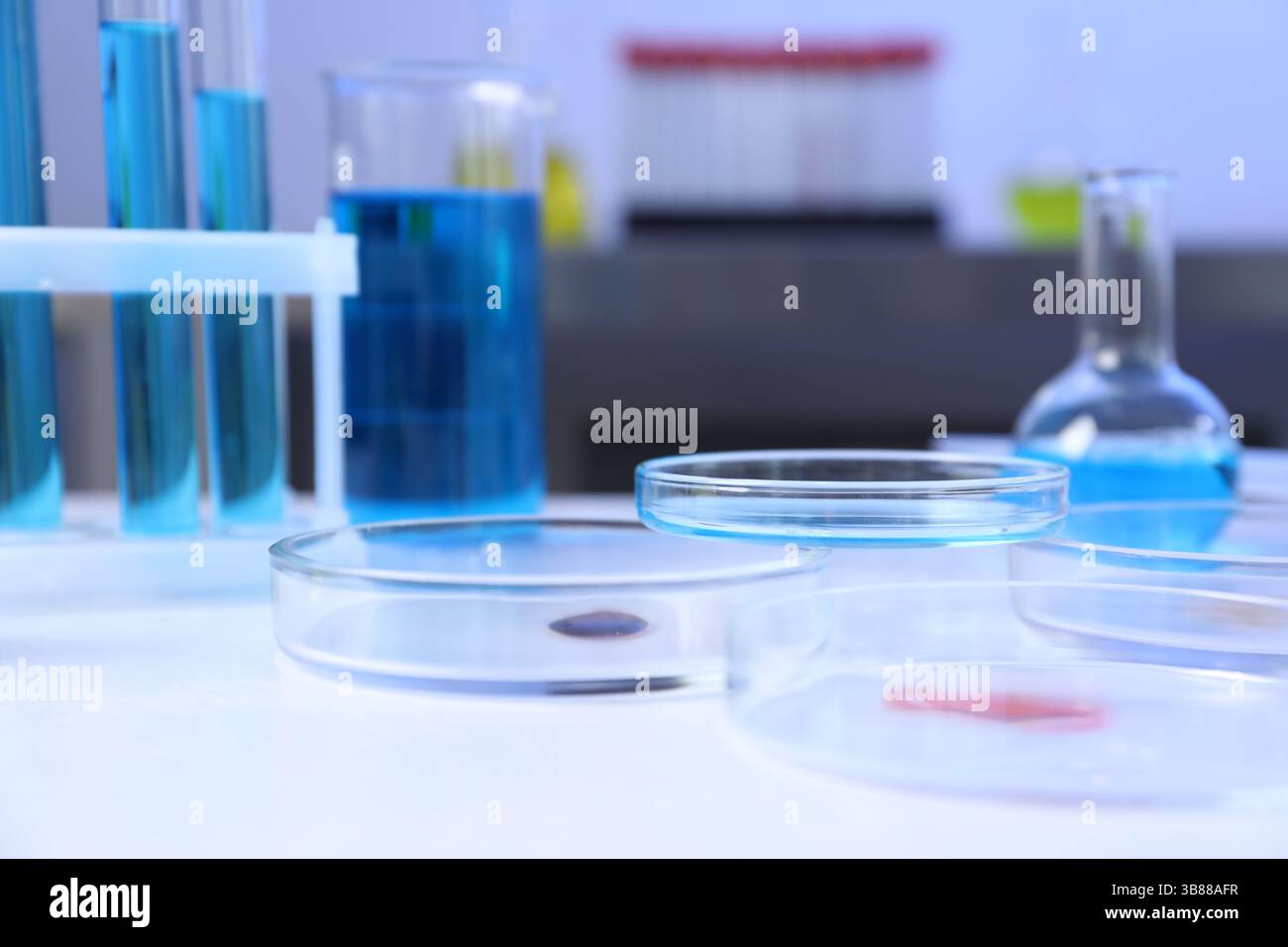 Petri dishes, flasks and test tubes with samples on white background ...