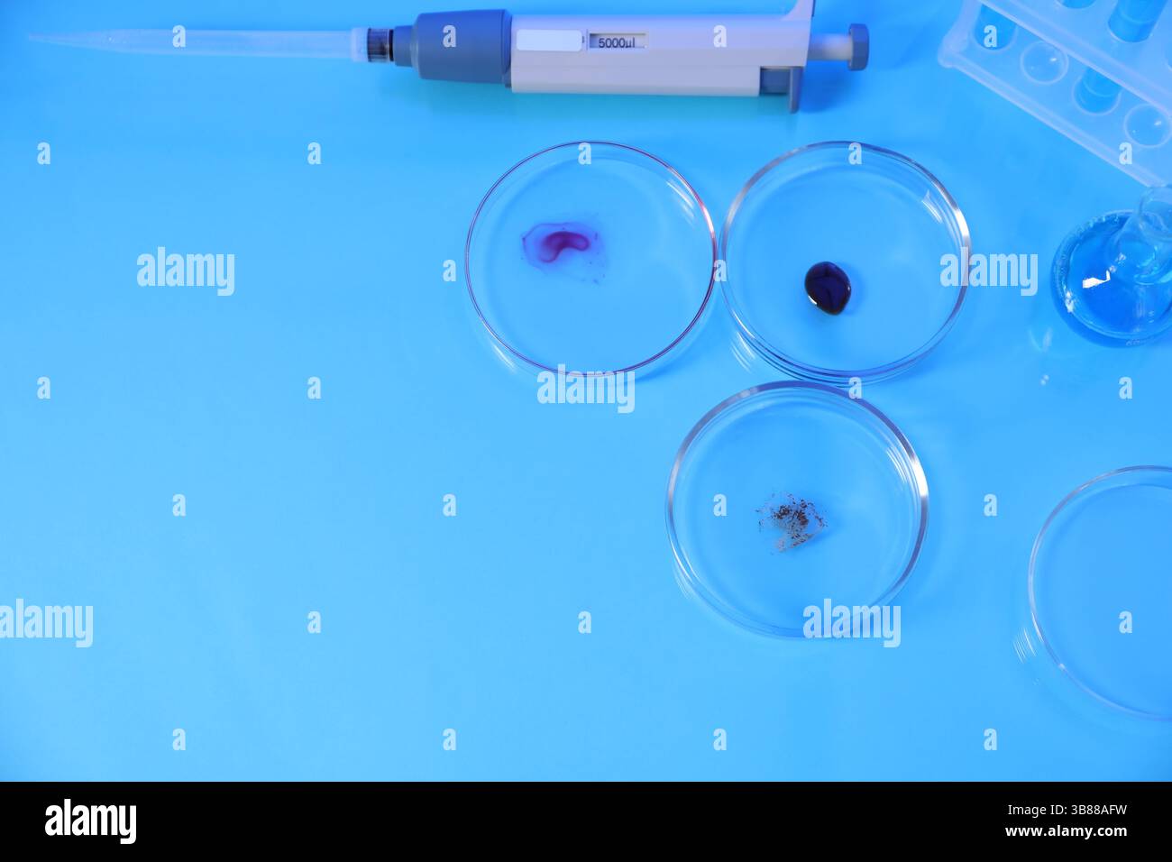 Petri dishes with samples, test tubes, micropipette and flask on light ...