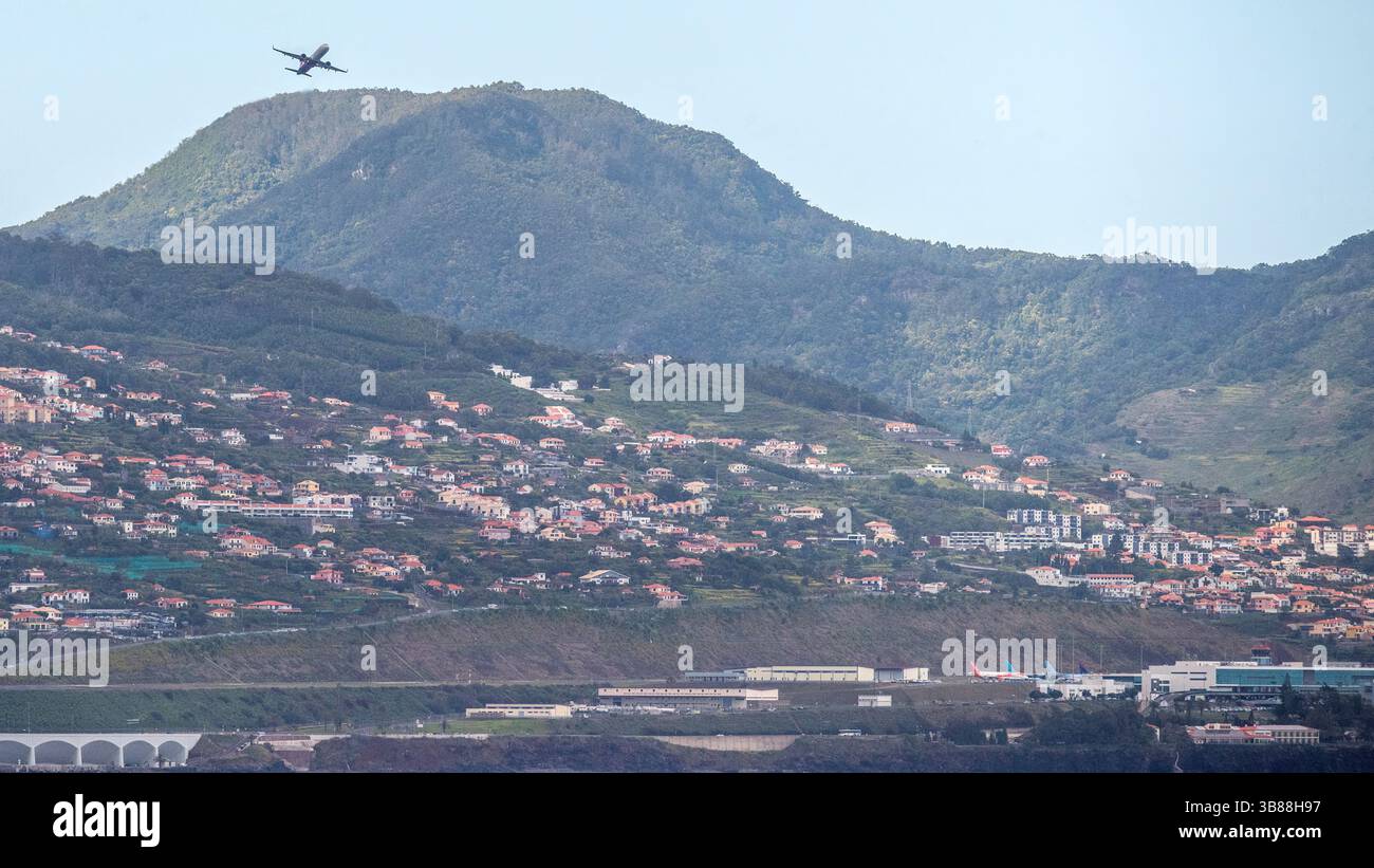 Madeira Funchal Airport (FNC) is known for its challenging runway. One end is built on concrete pillars with nearby steeply climbing terrain Stock Photo
