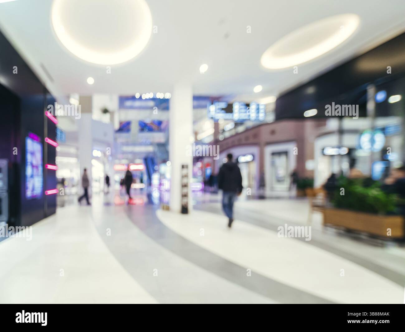 Shopping mall blur background with bokeh. Blurred hall of shopping mall with customers as background. Copy space Stock Photo