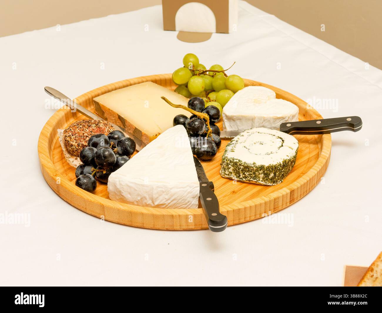 Wedding cheese platter with grapes and a heart-shaped cheese centerpiece, perfect for a romantic and gourmet celebration. Stock Photo
