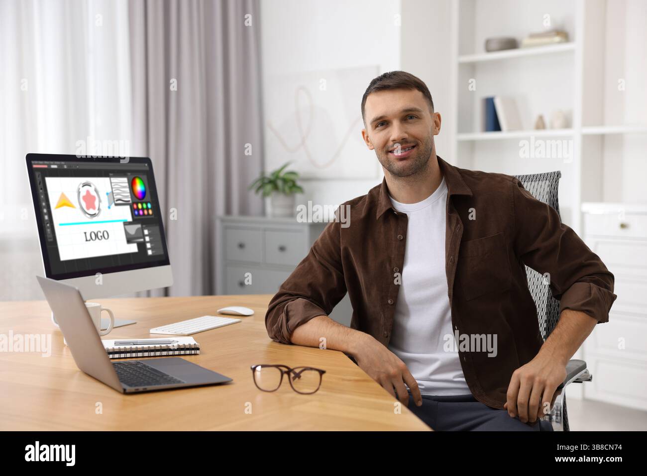 Designer working on different computers at table in office Stock Photo