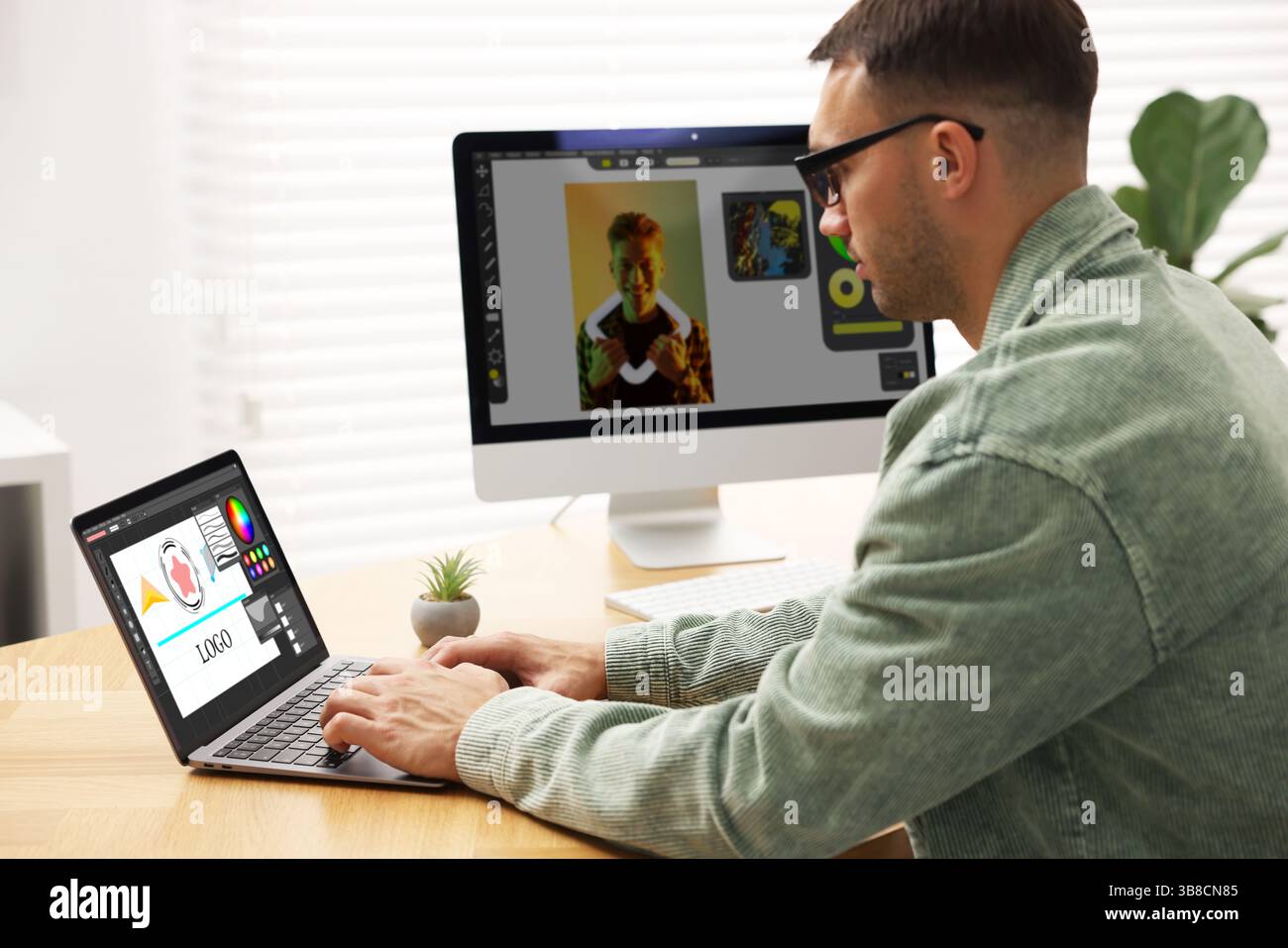 Designer working on different computers at table in office Stock Photo