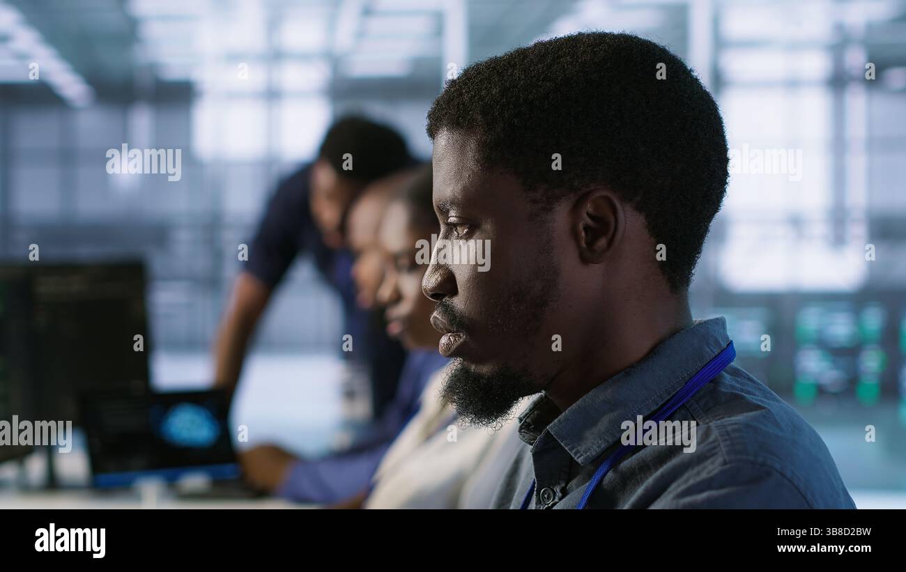 System administrators in data center implementing AI systems. Server farm specialists using artificial intelligence to identify hardware failures impacting operations, camera A handheld camera shot Stock Photo