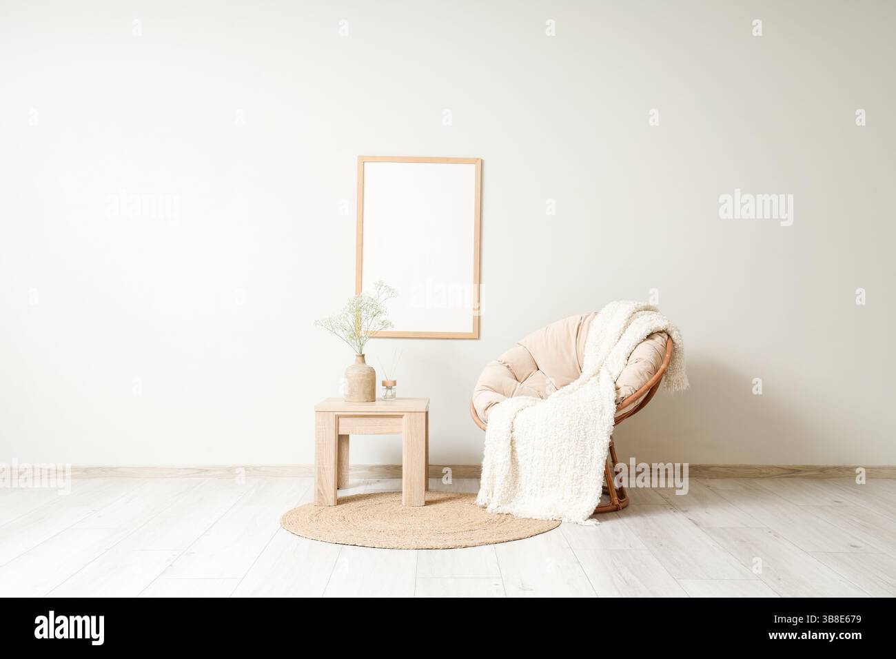 Coffee table with gypsophila flowers in vase and armchair in living ...