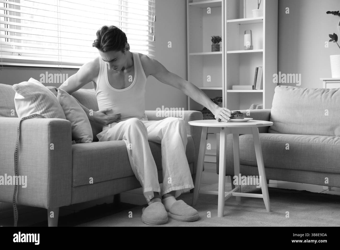Young man with anorexia refusing from bun at home Stock Photo