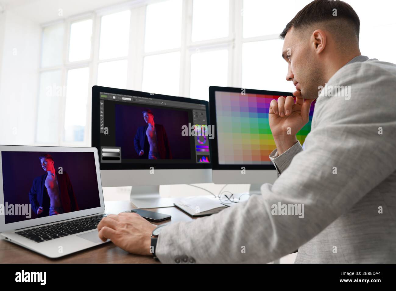 Designer working on different computers at table in office Stock Photo