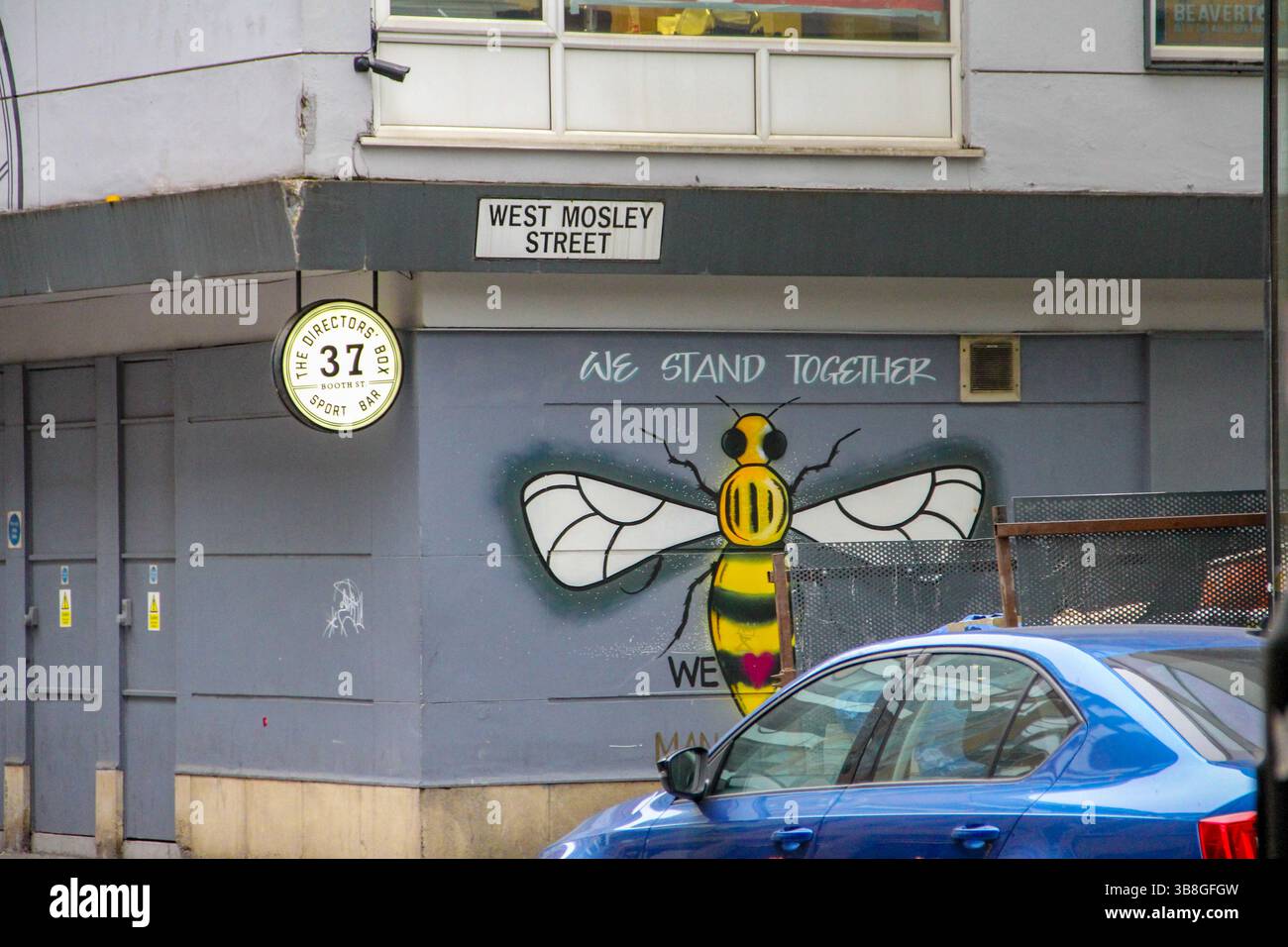 Manchester, UK - 11.16.2024: Street view with Beetham Tower reflections and Manchester’s unique architecture and signage. Manchester bee symbol spraye Stock Photo