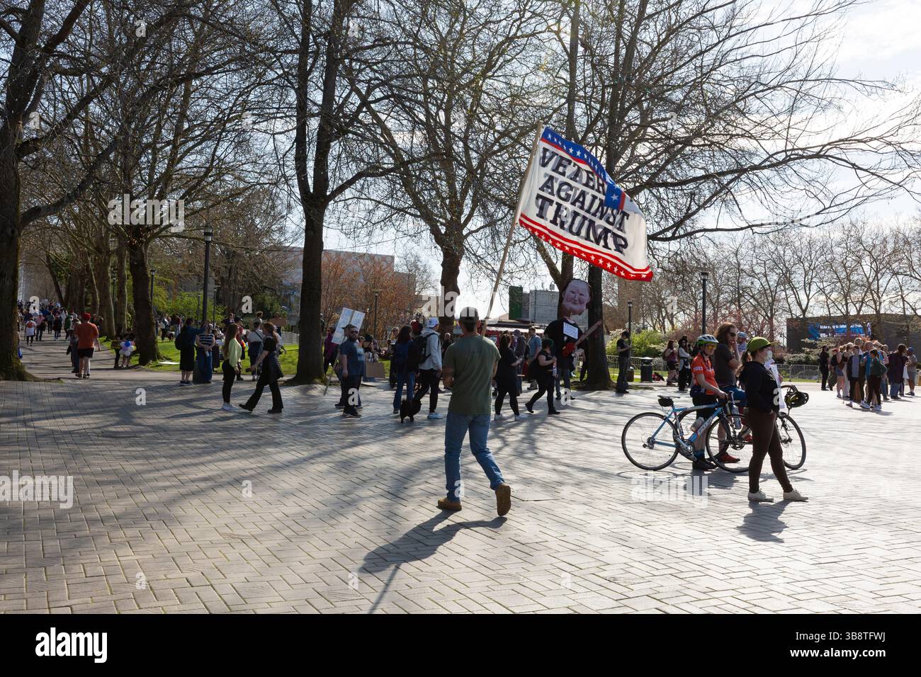 A Marine Corps veteran walks through Seattle Center with an anti-Trump flag as the “Hands Off!” rally in Seattle disperses on Saturday, April 5, 2025. Stock Photo