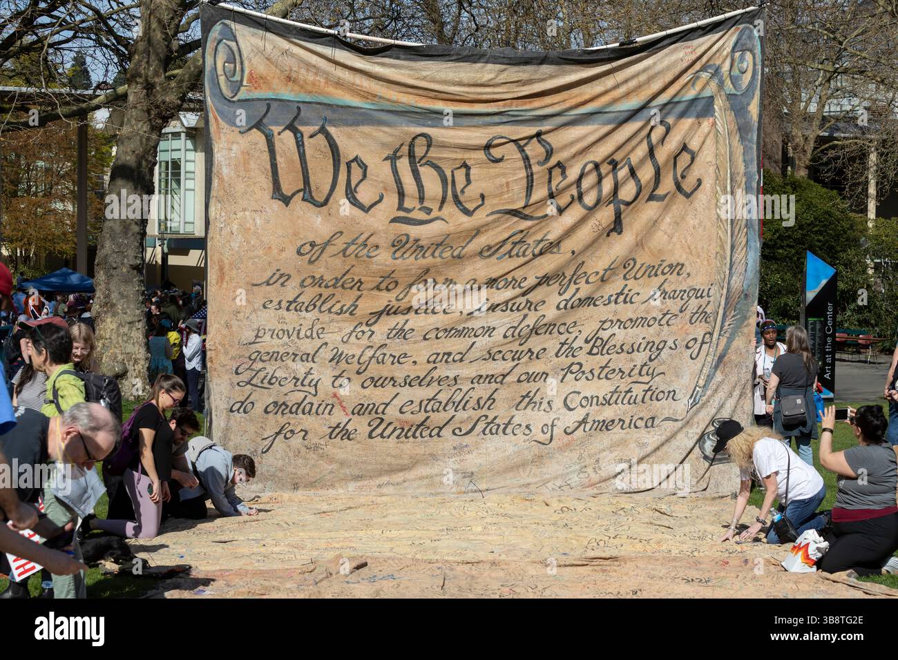 Supporters sign their names to a monumental Backbone Campaign banner in the form of the preamble to the Constitution at Seattle Center during the “Han Stock Photo