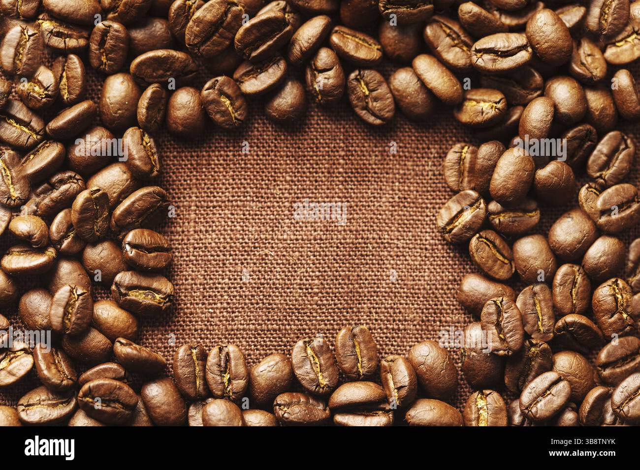 Spilled coffee beans frame over linen textile Stock Photo