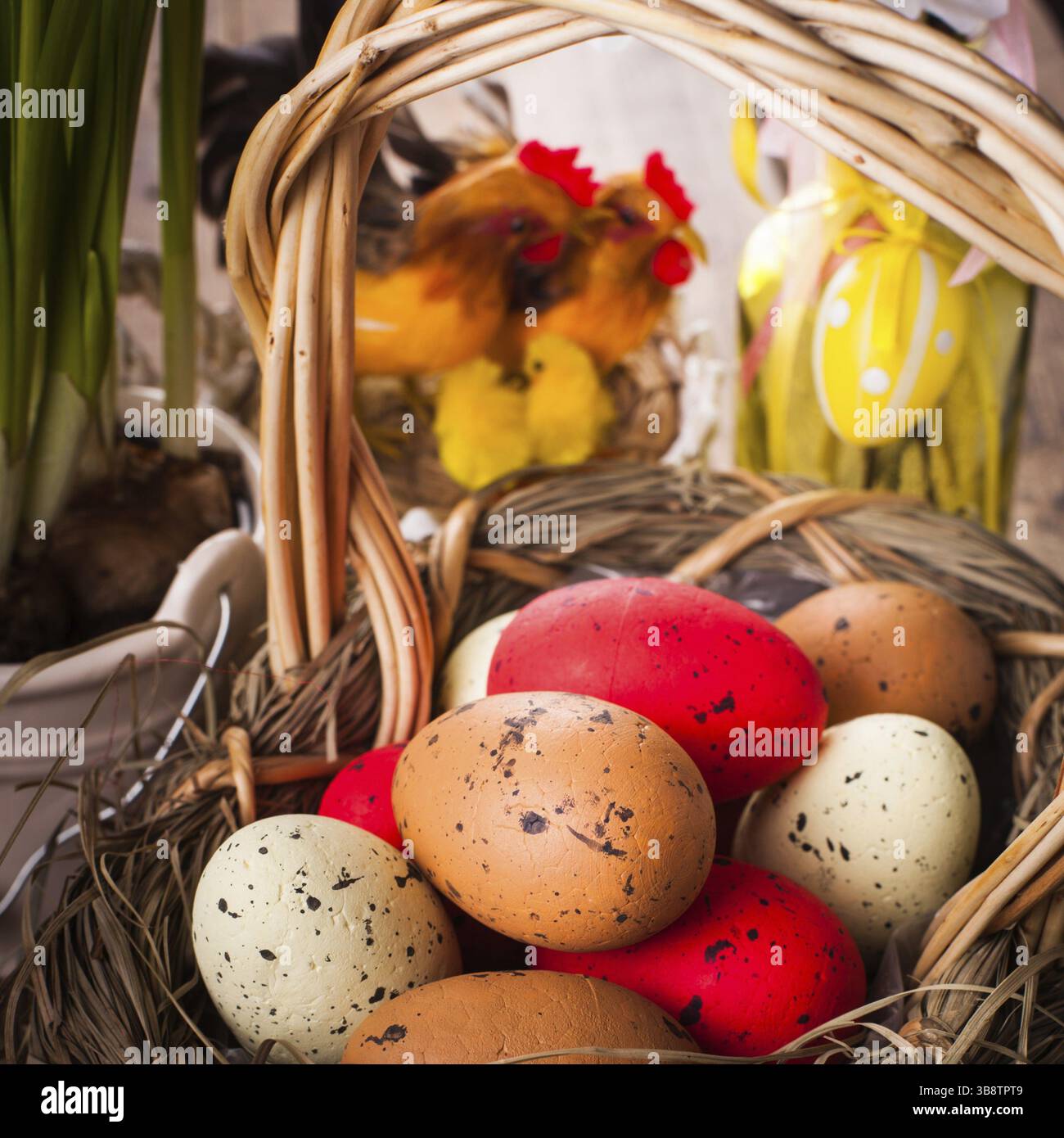 Brown, red and yellow eggs in basket, Easter decor Stock Photo
