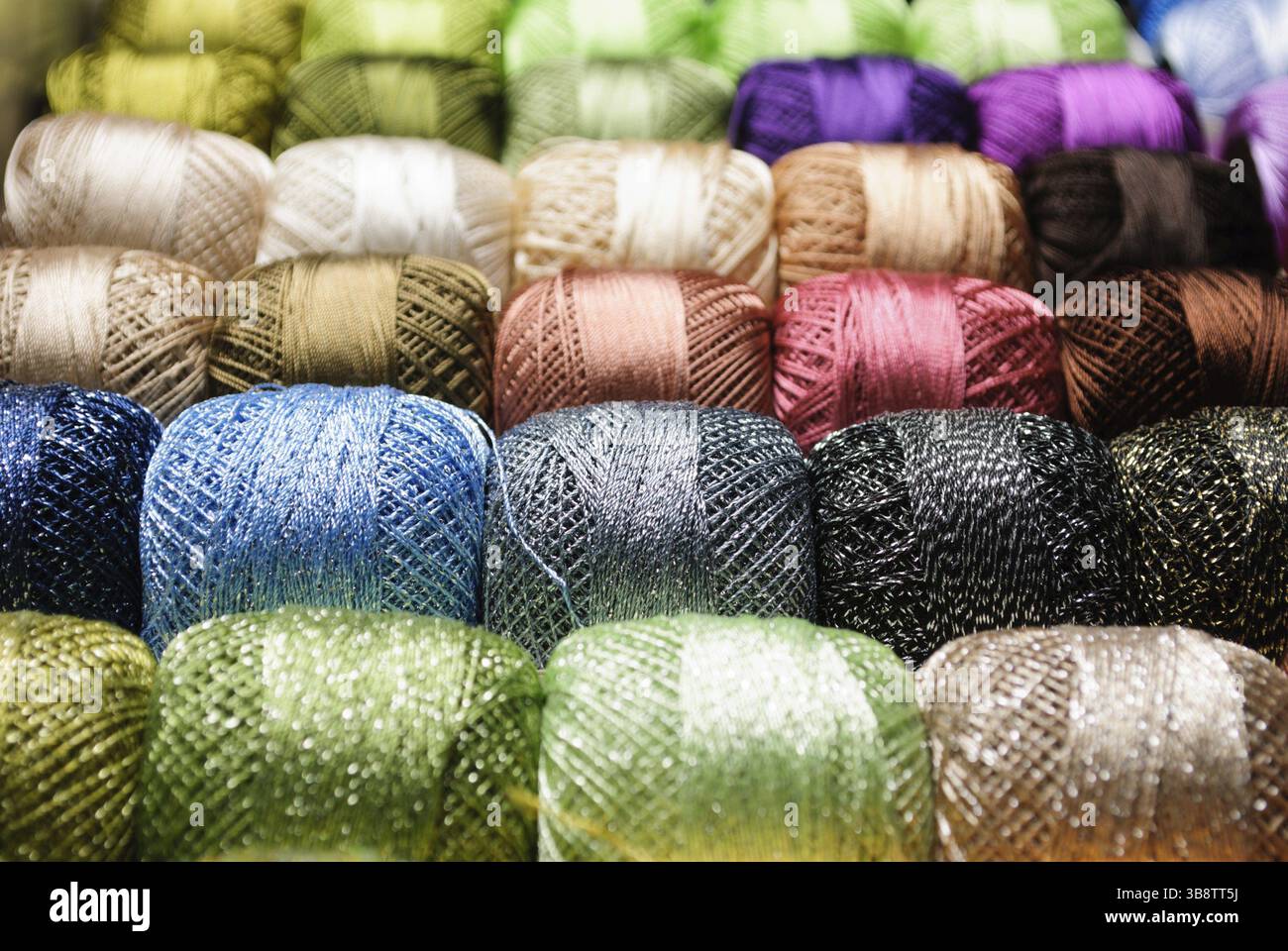 Different color threads on rows in the store Stock Photo - Alamy