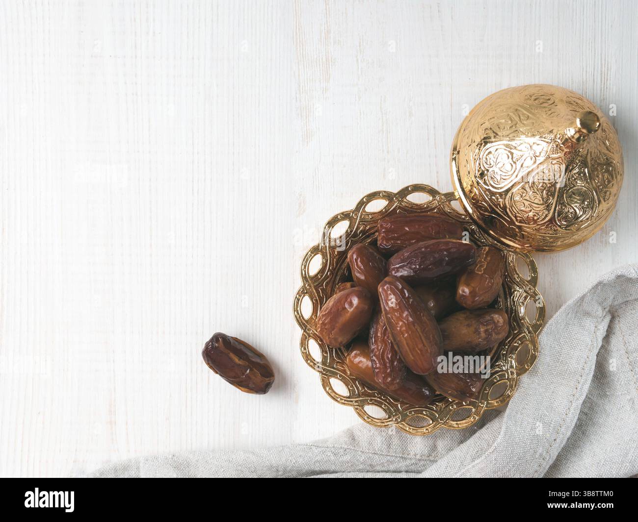 Metal plate of sweet dried dates and linen cloth on gray cement background. Dried dates with copy space. Top view or flat-lay Stock Photo