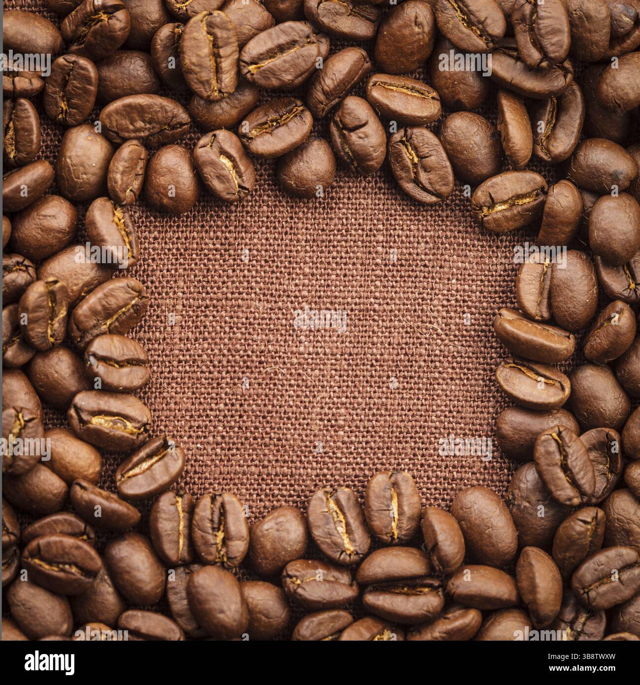 Spilled coffee beans frame over linen textile Stock Photo