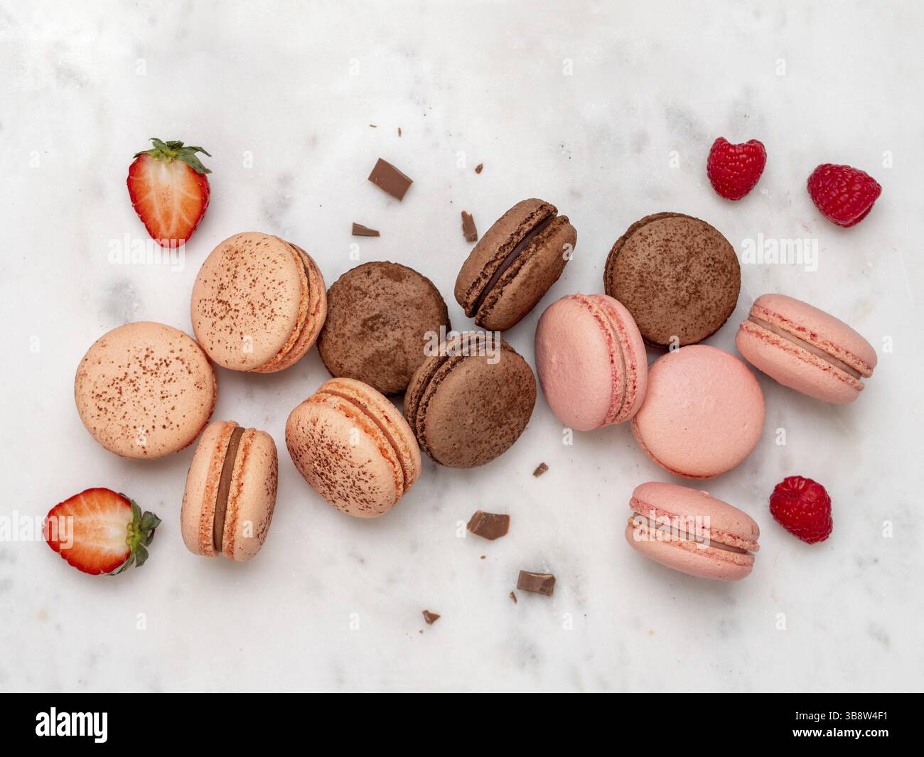 Composition with french macarons on white marble background. Top view of colorful pastel macaroons or macaron with berries and chocolate Stock Photo