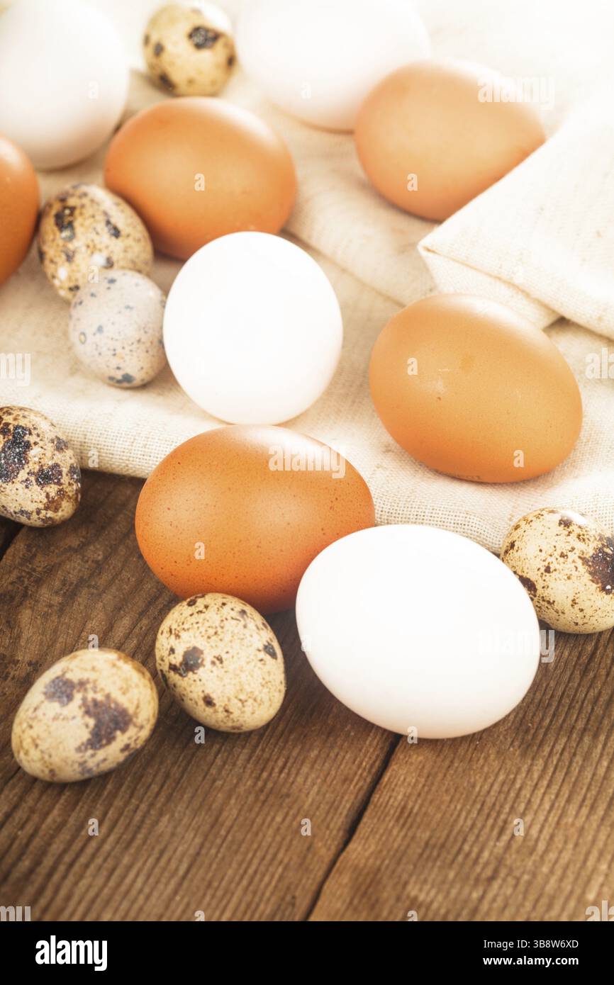 Eggs on textile tablecloth over rustic wooden table Stock Photo