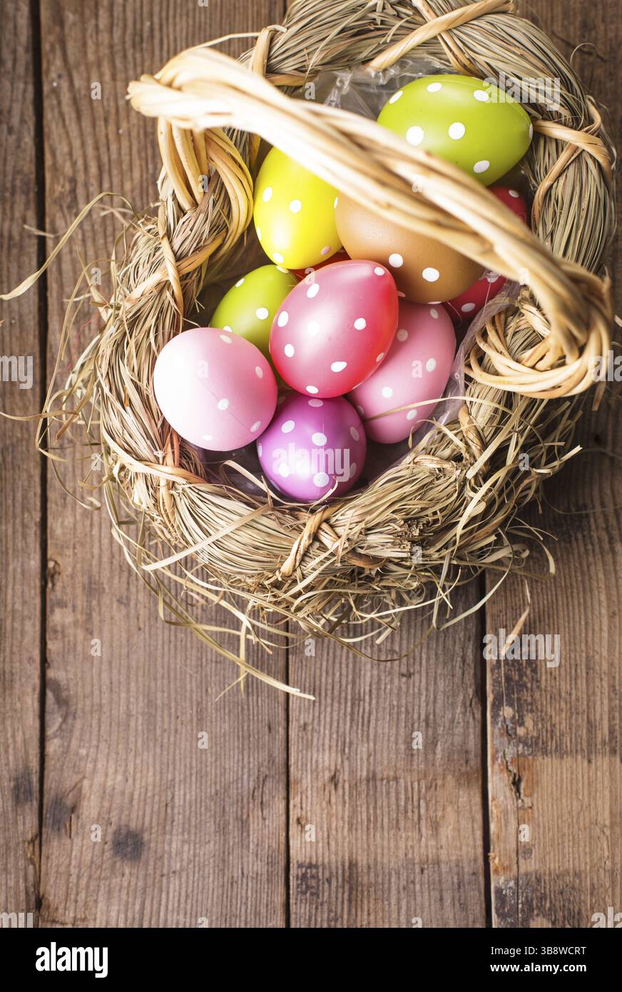 Colorful polka dot eggs in basket with copy space, Easter decorations Stock Photo