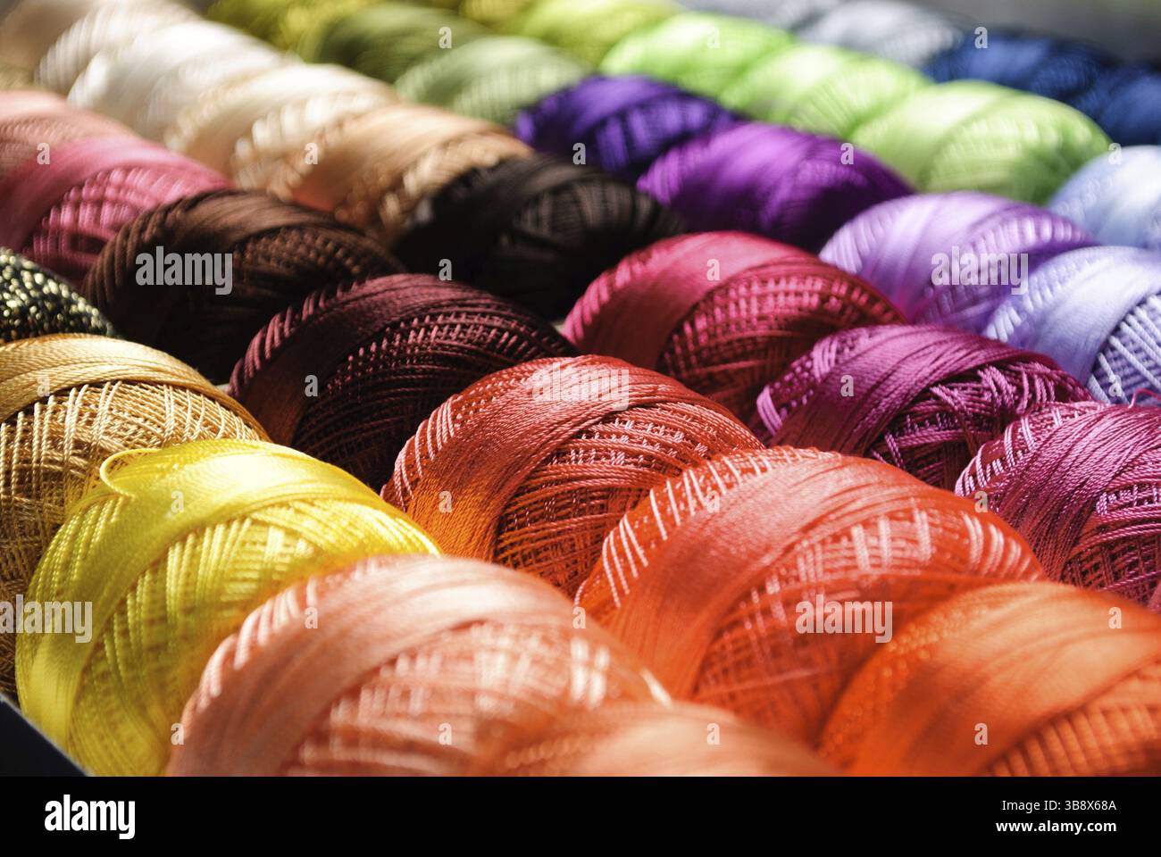 Different color threads on rows in the store Stock Photo - Alamy