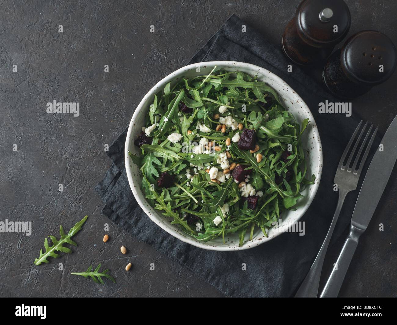 Beetroot, aragula and soft cheese salad over black background. Top view or flat lay. Copy space for text. Idea and recipe for healthy vegetarian salad Stock Photo