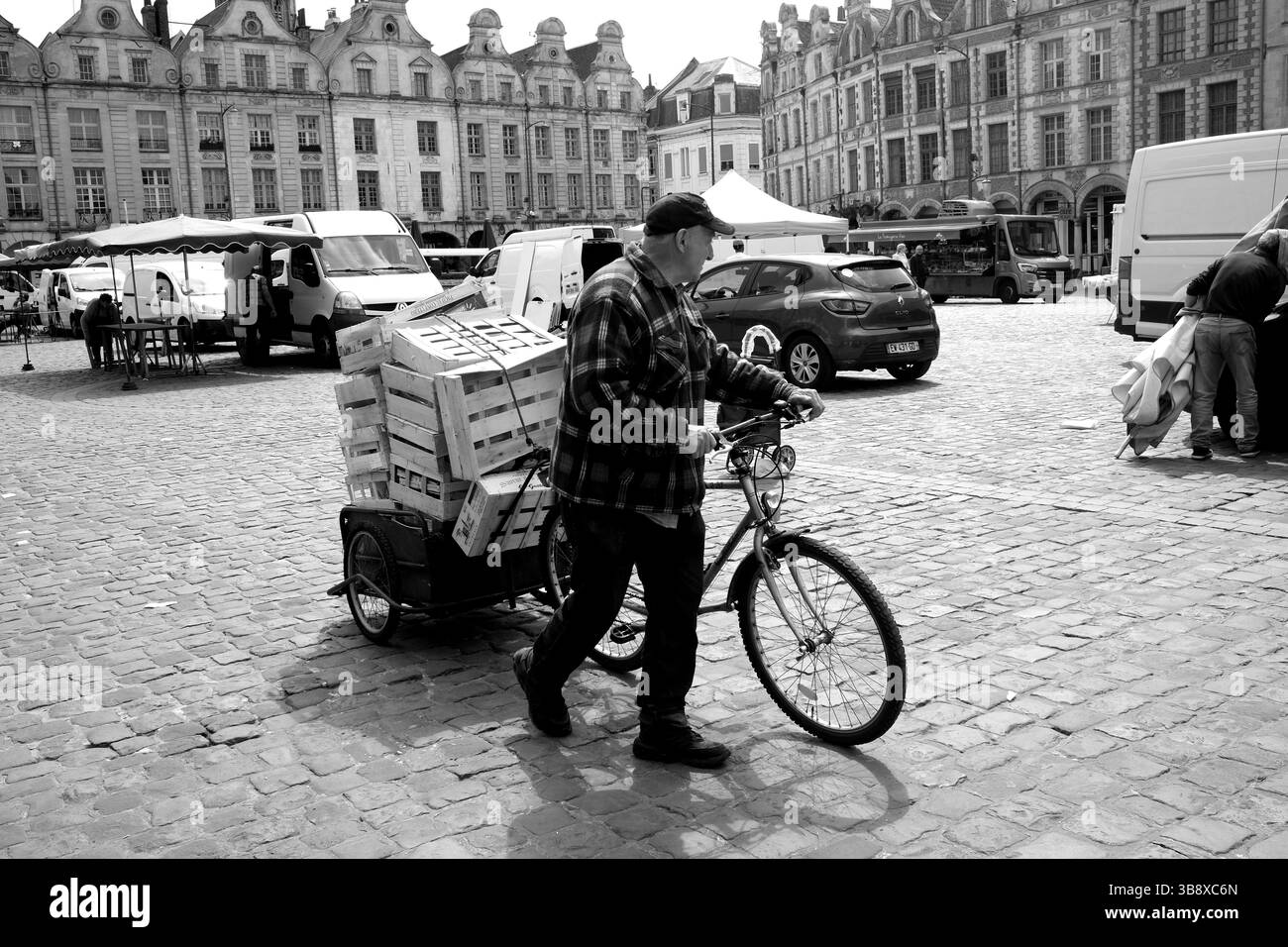 The Place des Héros in Arras in Pas-de-Calais, Northern France. outdoor market stall holders closing as man helps collect wooden pallets Stock Photo