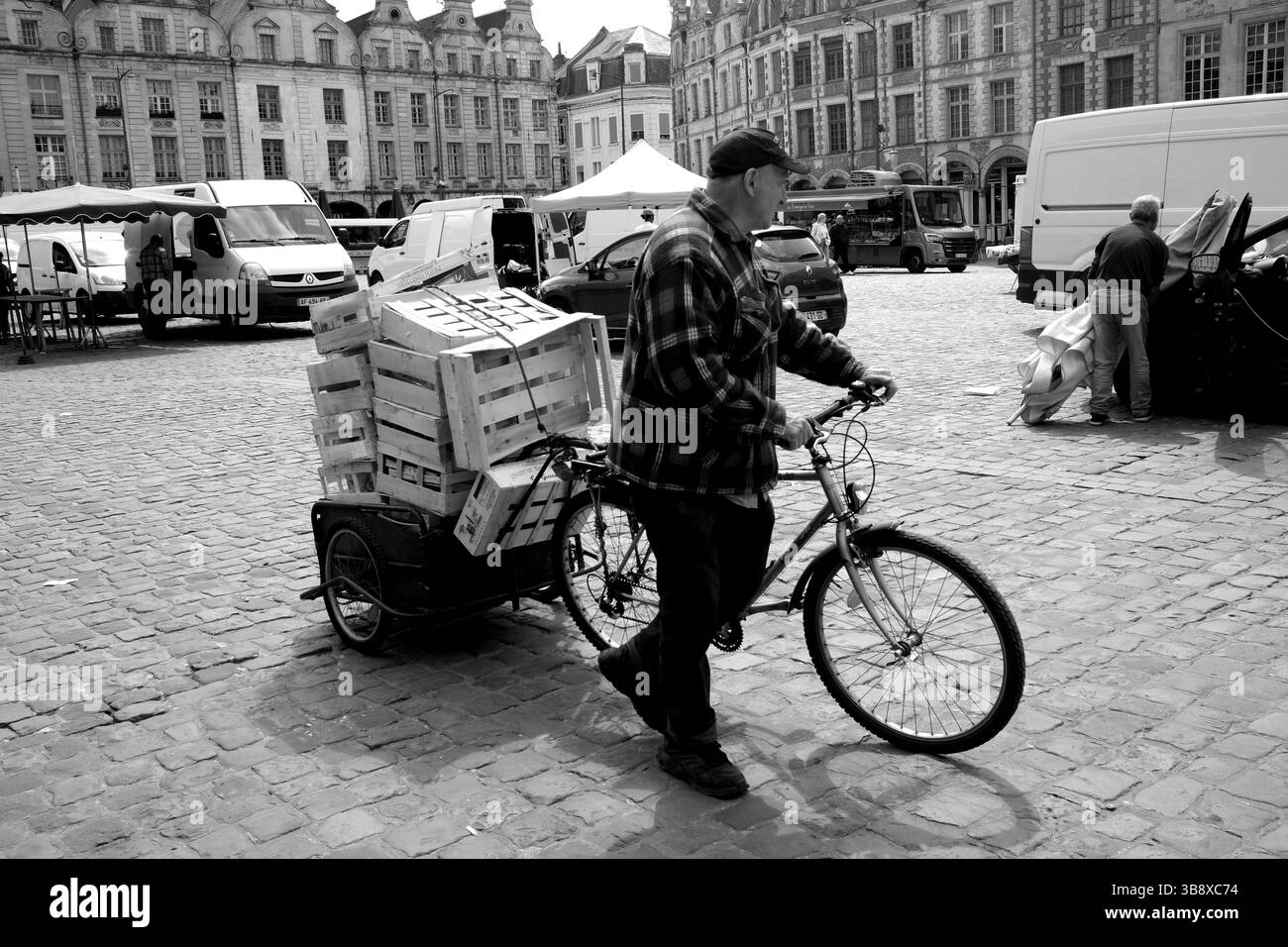 The Place des Héros in Arras in Pas-de-Calais, Northern France. outdoor market stall holders closing as man helps collect wooden pallets Stock Photo
