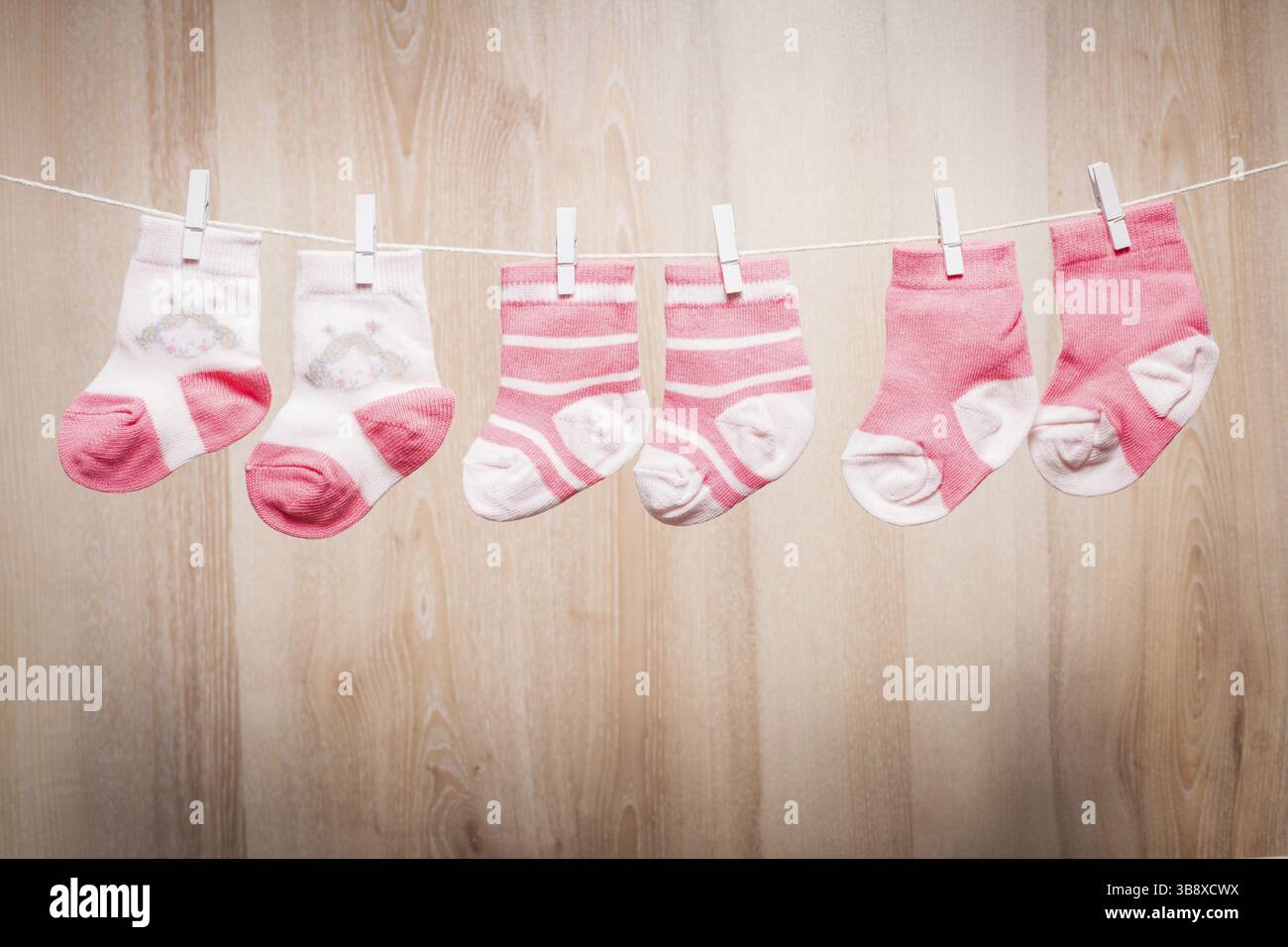 Baby girl socks attached to the rope Stock Photo - Alamy
