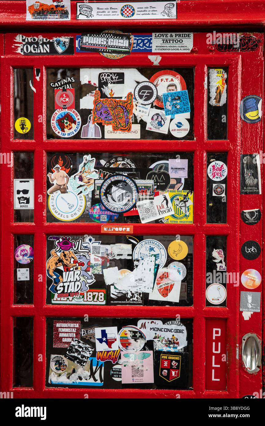 Stickers on the door of a red phone box Stock Photo - Alamy