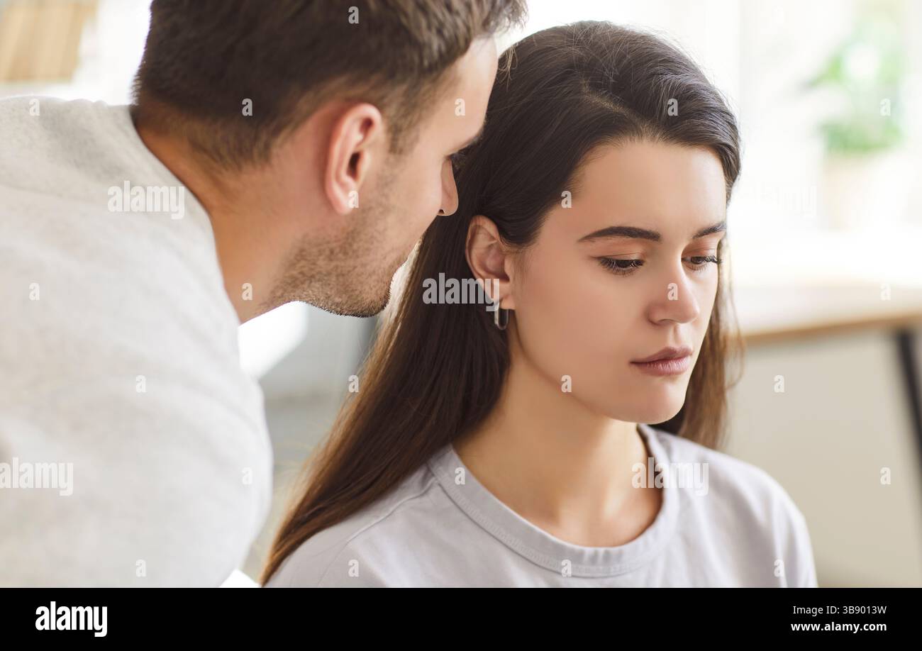 Intimate moment of a partner leaning close to whisper tenderly into the ear