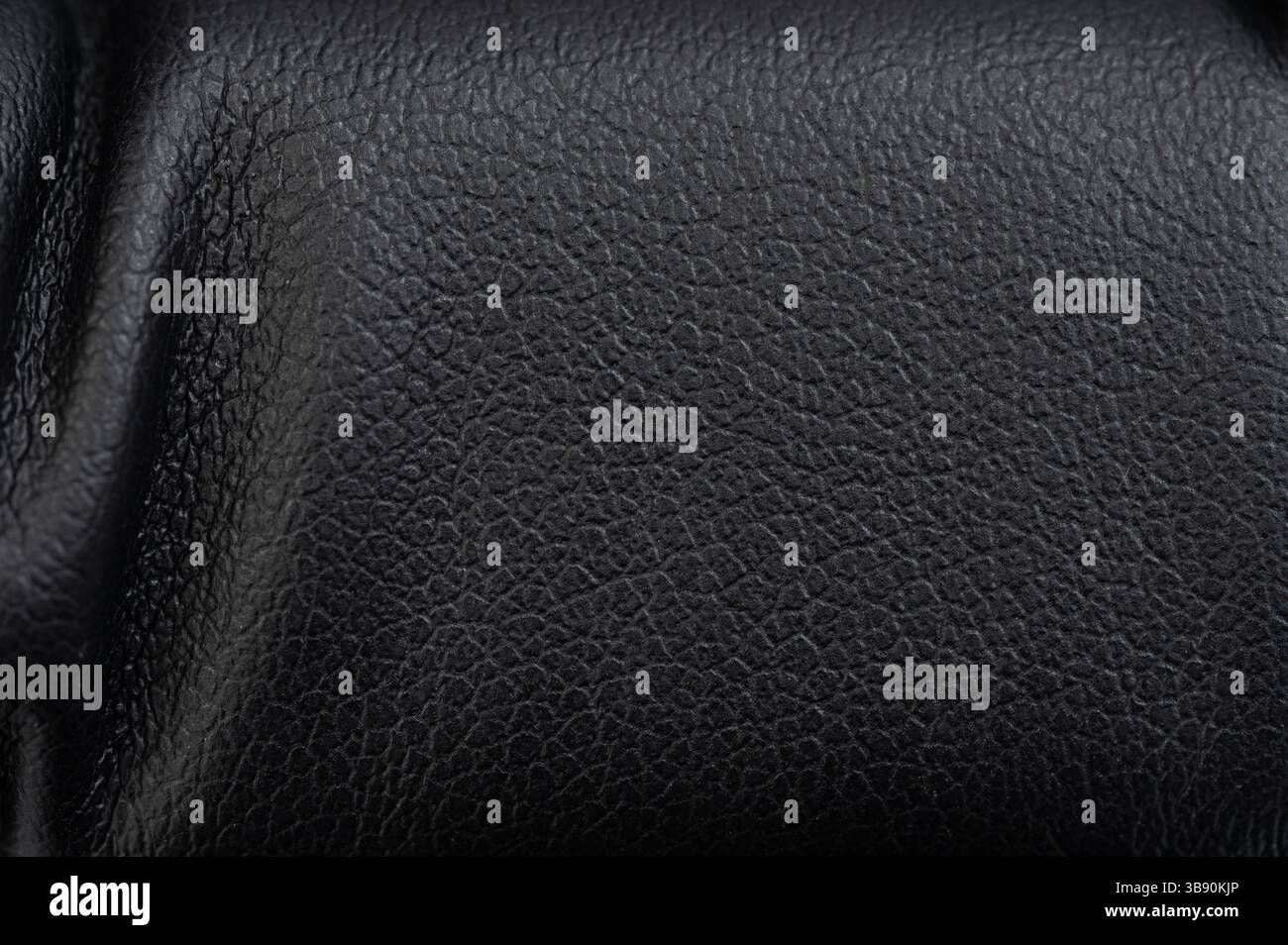 Soft black leather surface displays subtle textures and fine patterns under soft lighting, enhancing its elegance. Stock Photo
