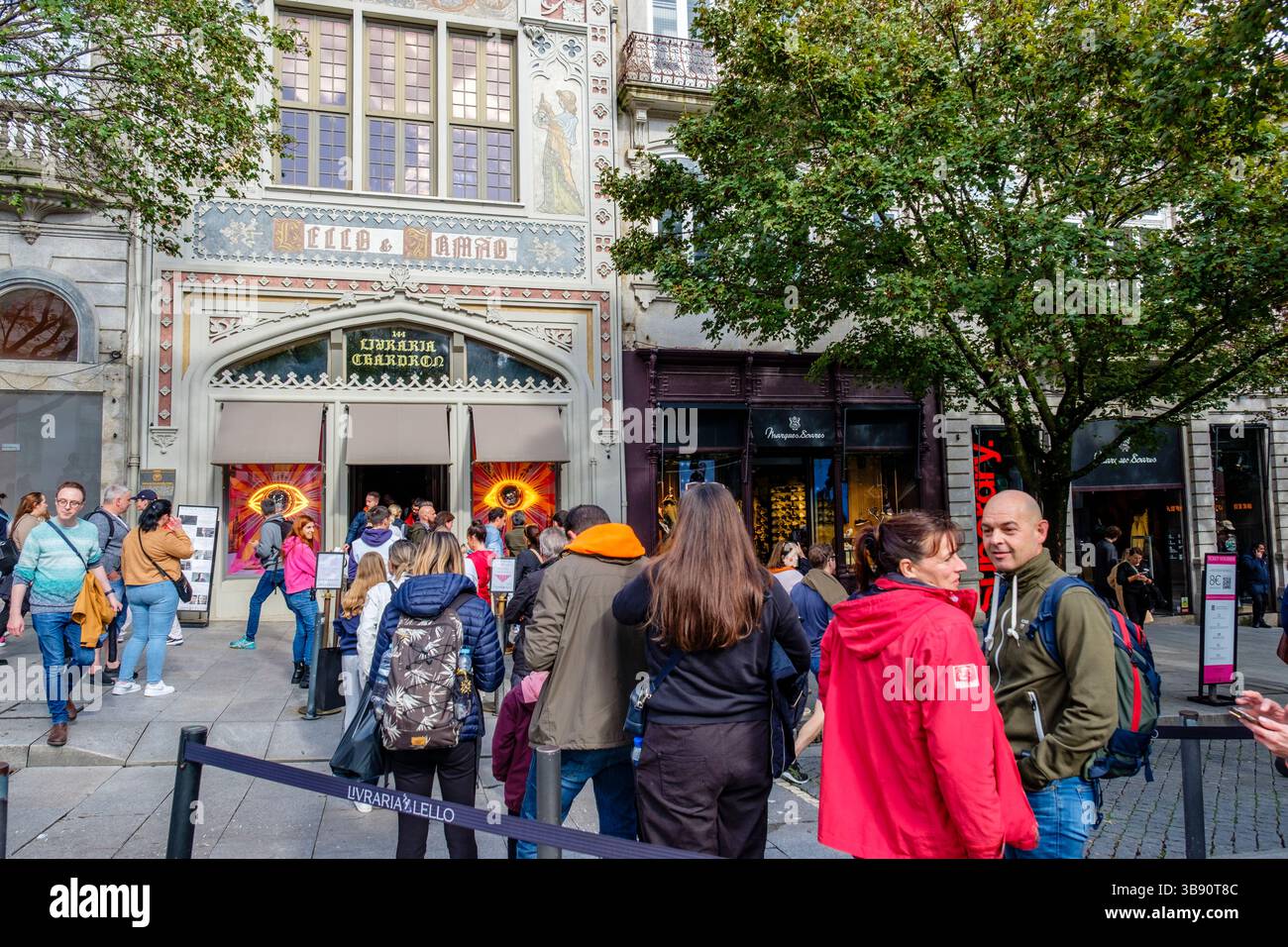 Mass tourism, tourists in line to visit Livraria Lello & Irmão, Lello Bookstore facade, by architect Francisco Xavier Esteves, Porto, Portugal Stock Photo